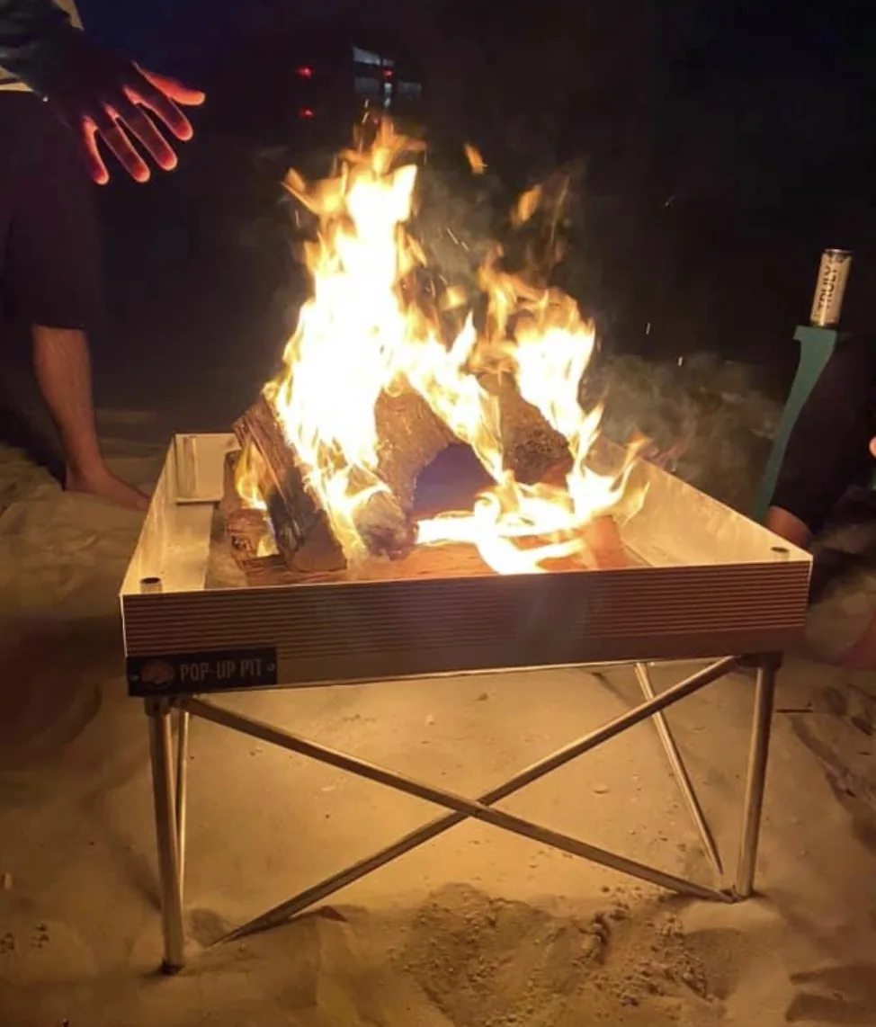 Raised portable fire pit burning on the sand at night at Indian Pass